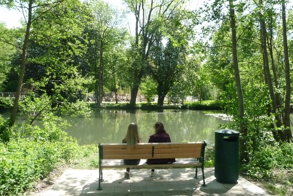 Ein Foto von einer Bank am Ehrlicherpark mit Besuchern, die auf eine Wasserfläche sehen&nbsp;&copy;&nbsp;66.4.1 Bertram